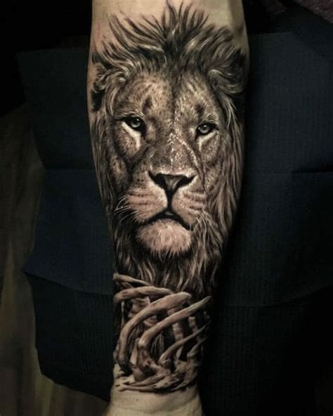 Realism lion tatoo on the arm with a high level of detail and a meal in the jungle.